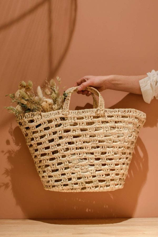 Panier ajouré en fibres naturelles tenu à la main