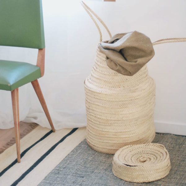 Panier à linge en feuilles de palmier dans une chambre