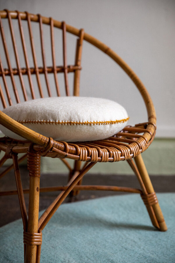 Coussin Muskhane sur une chaise en feutre de laine blanc
