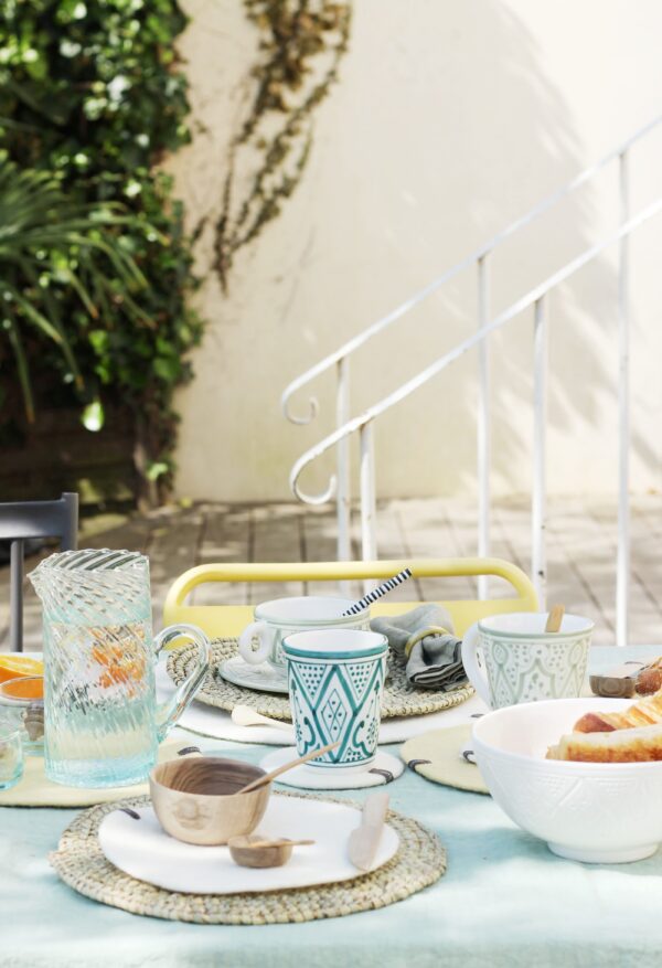 Verre bleu en céramique sur une table d'été colorée