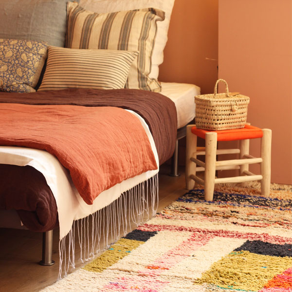 tabouret marocain fait main en corde tressée couleur orange dans une chambre